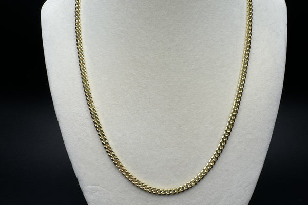 14k yellow gold Cuban link chain displayed on velvet bust - Ott Family Jewelry